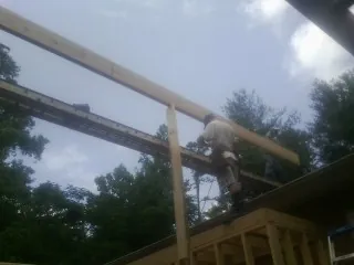 Carpenter setting a ridge beam over a new addition frame — Ice Dam Removal by Roofing Brothers in Whiteman Air Force Base