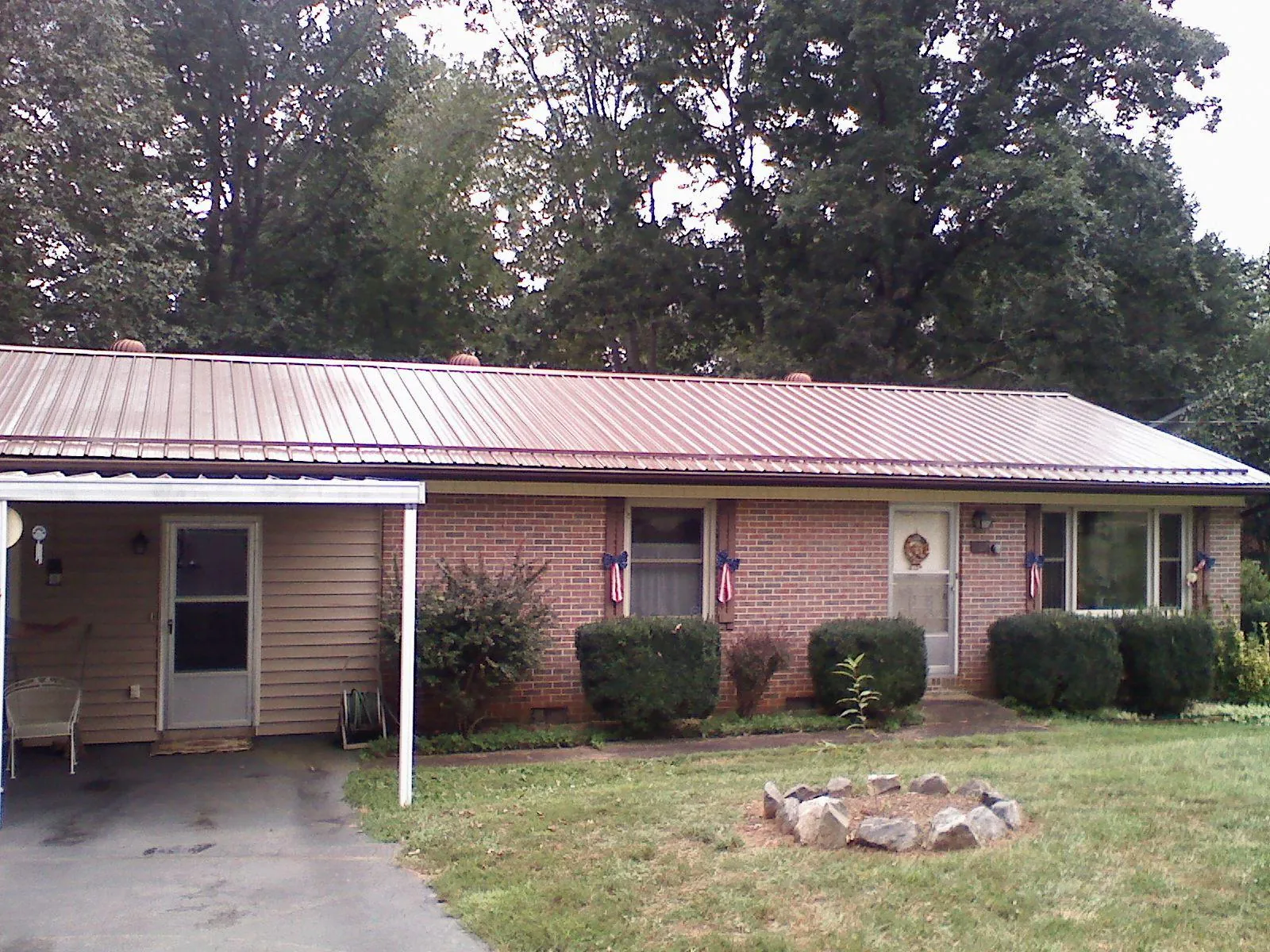 Bronze metal roof and carport on a brick ranch home — Roof Repair work by our crew in Whiteman Air Force Base